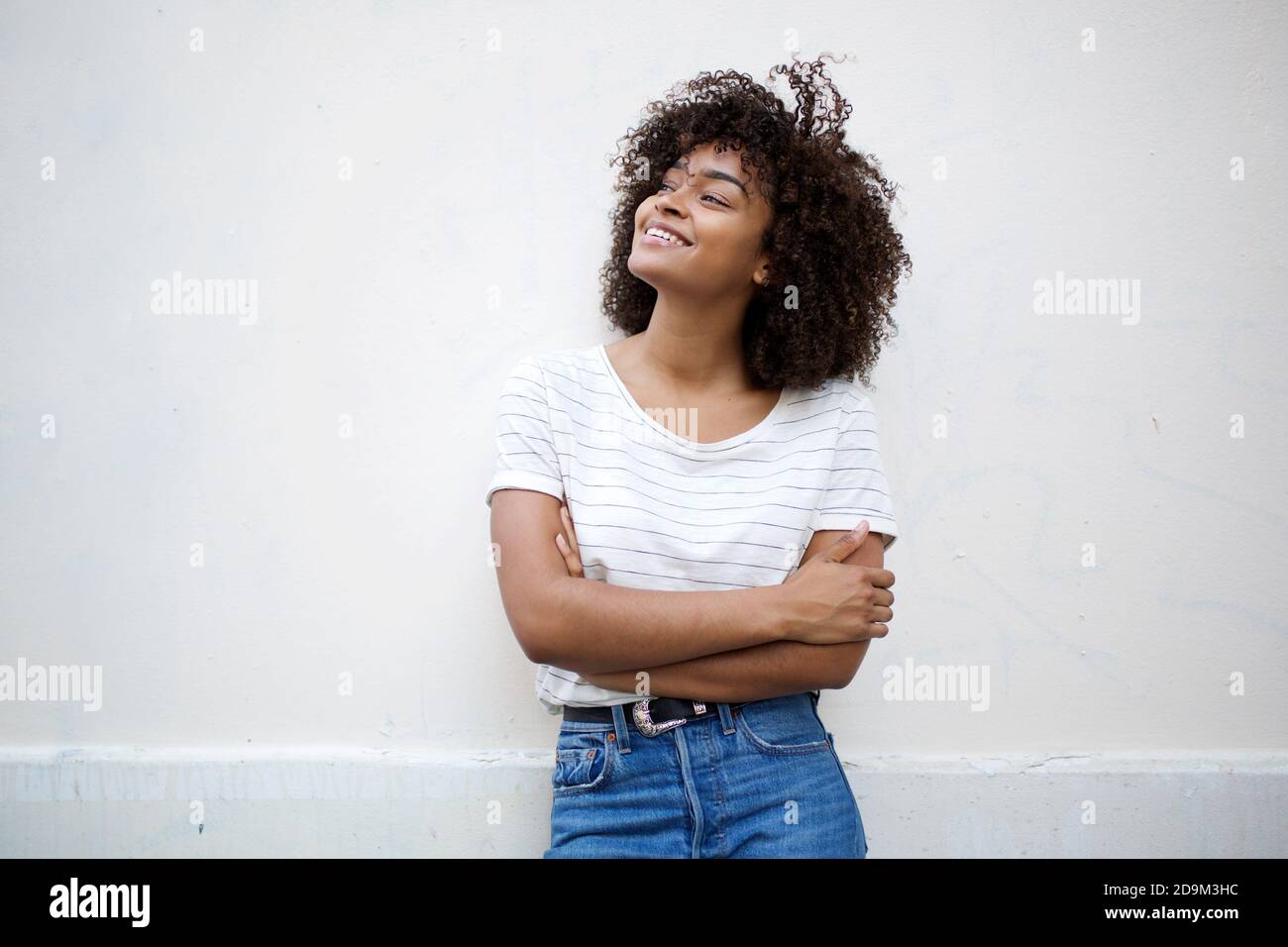 Portrait happy young african american woman with curly hair by white ...