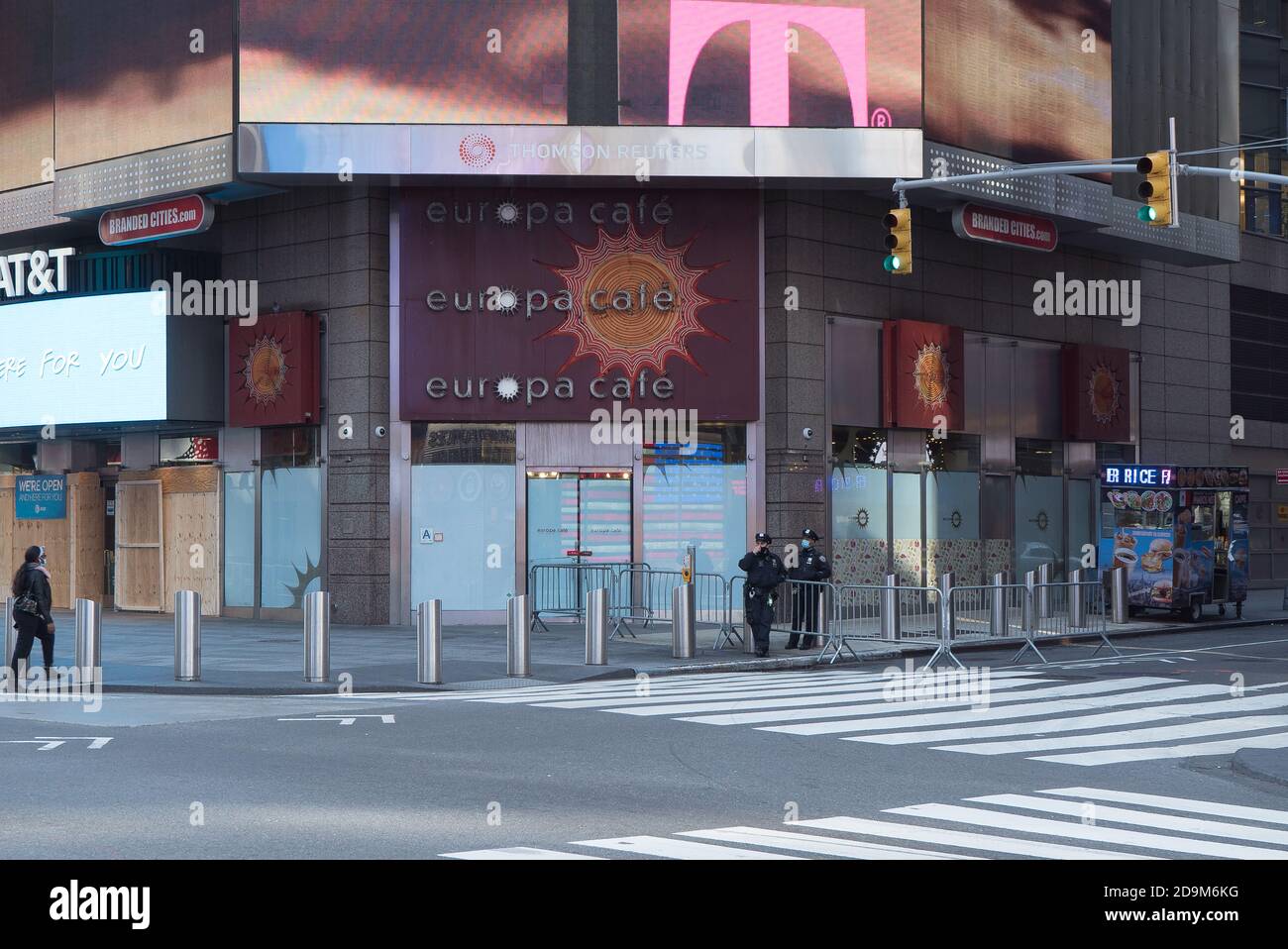 Two policemen wearing masks stand in front of a closed Europa Cafè in Times Square. Stock Photo