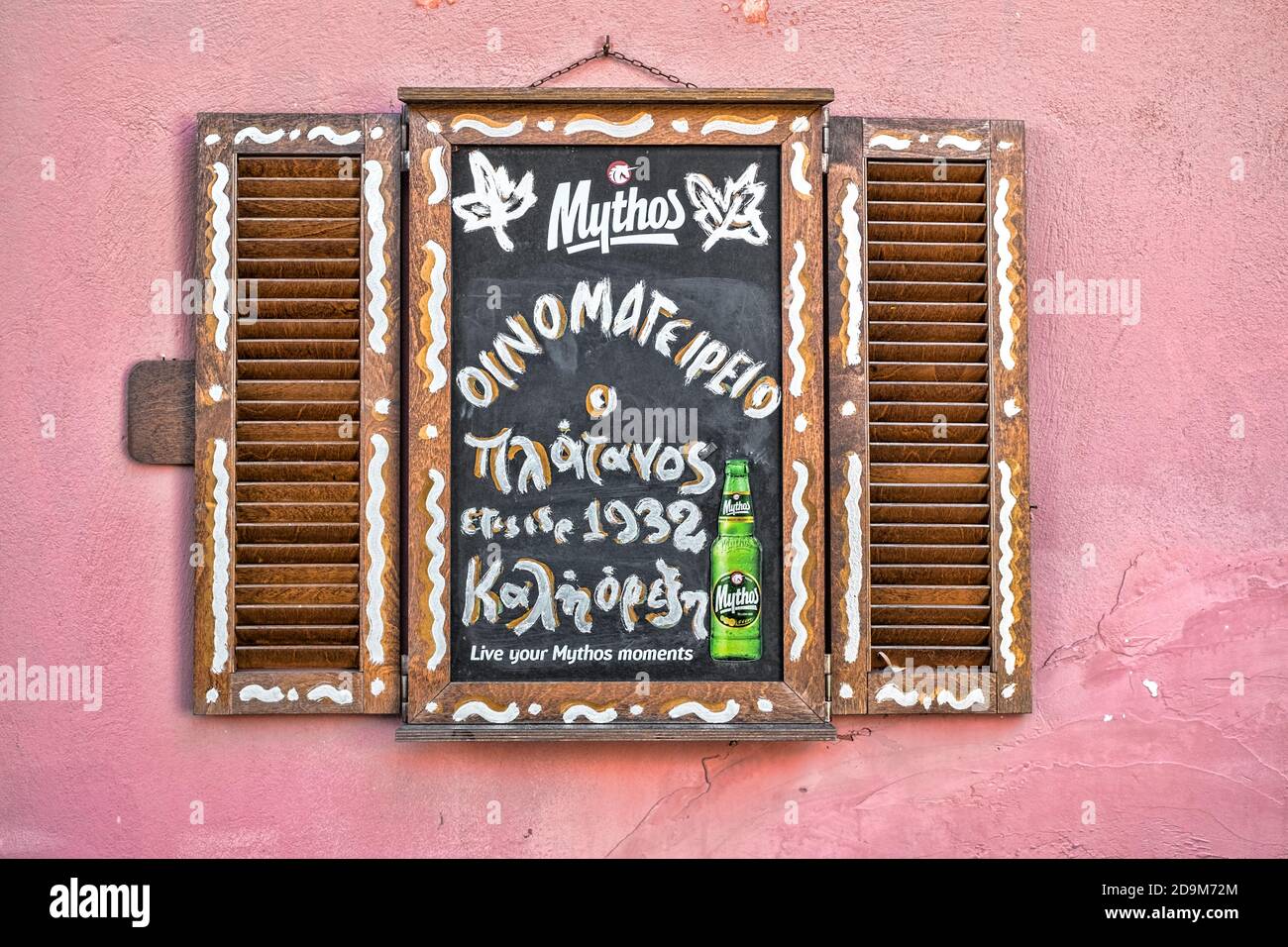 Athens, Greece - February 18, 2020. window wooden shutters with chalk board Mythos beer advertising at a restaurant in Athens, Greece Stock Photo