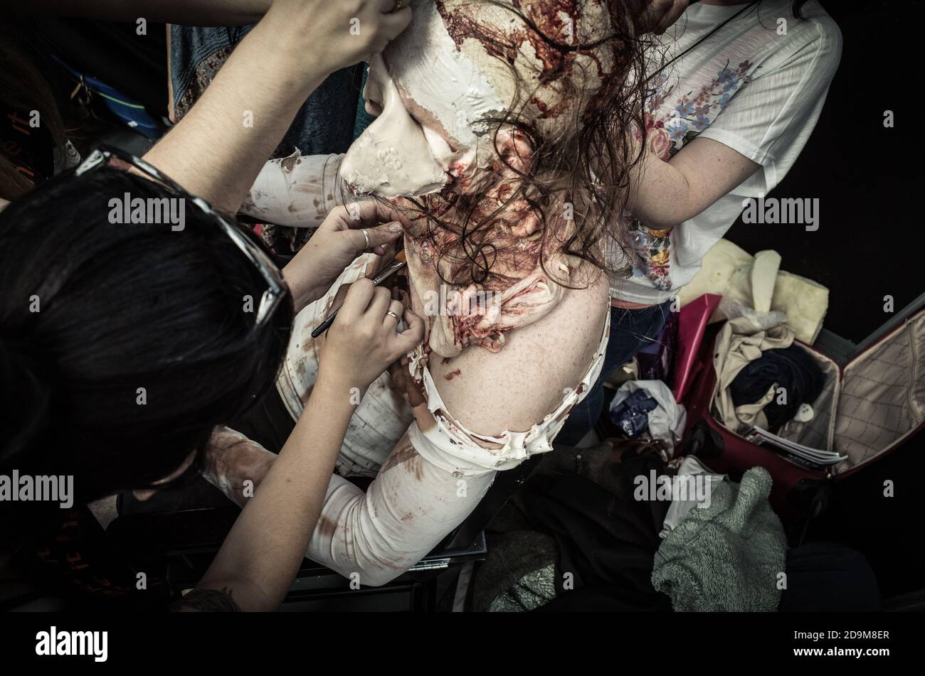 Make up artist applying special effects prosthetic mask Stock Photo