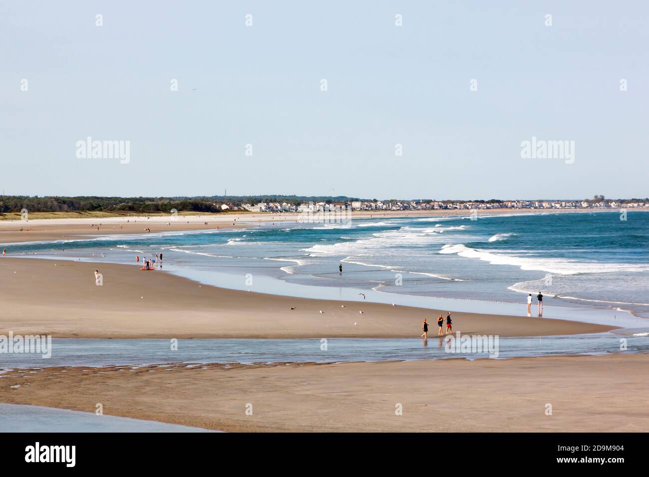 People walking along tidal flats during low tide at Ogunquit Beach in