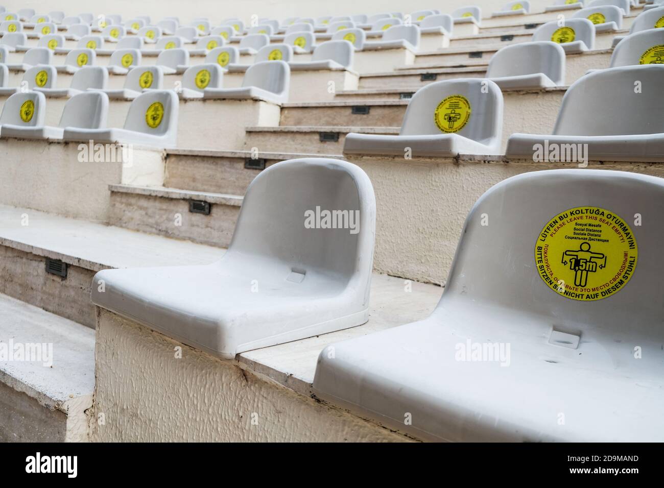 Avoiding crowds during show in amphitheater. Warning sign: leave some seats free for social distancing during coronavirus outbreak. New normal life Stock Photo