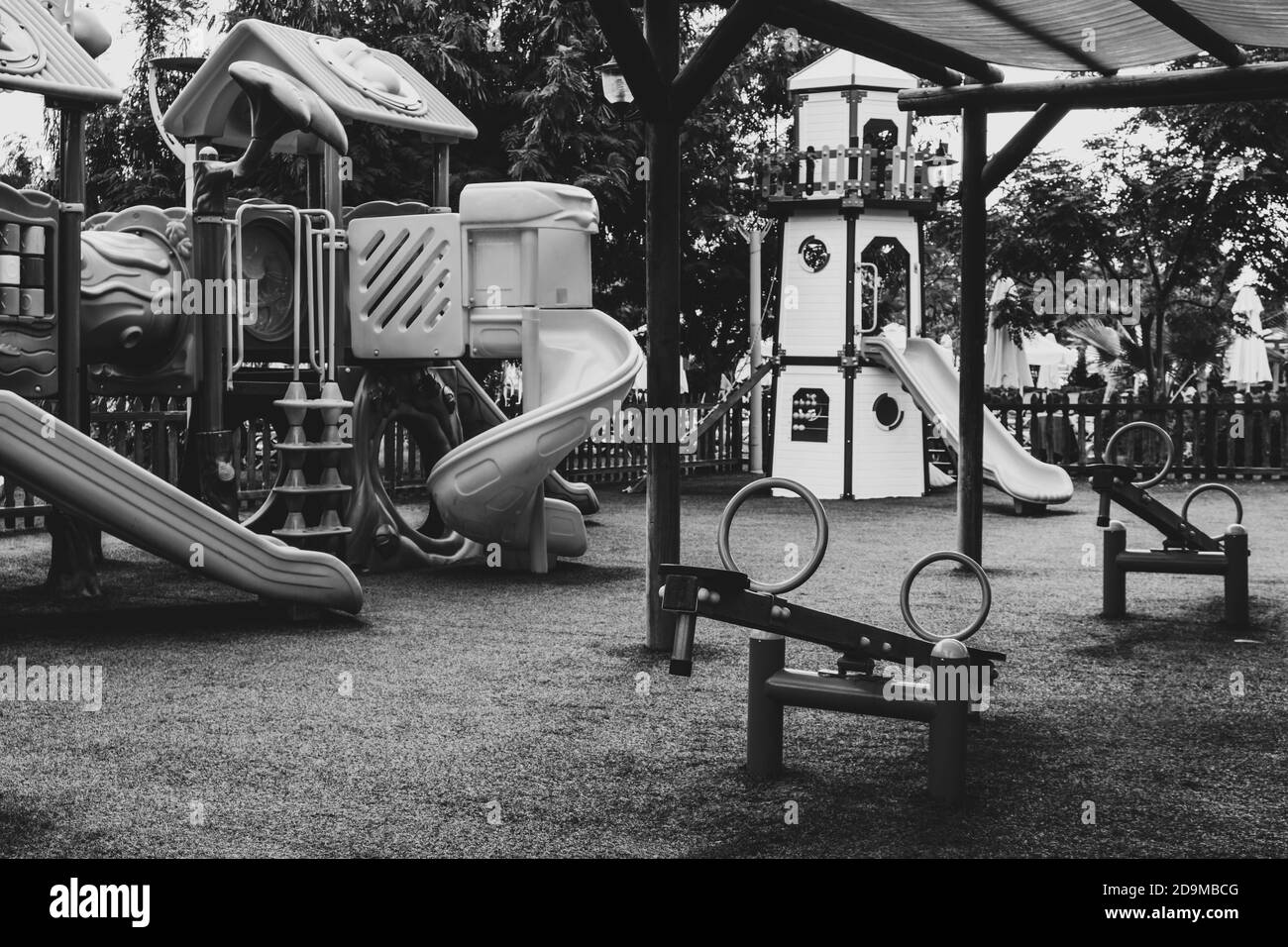 Empty swings on deserted kindergarten playground. Unattended slide and swing set during coronavirus outbreak. Closed for children in pandemic. Nobody Stock Photo