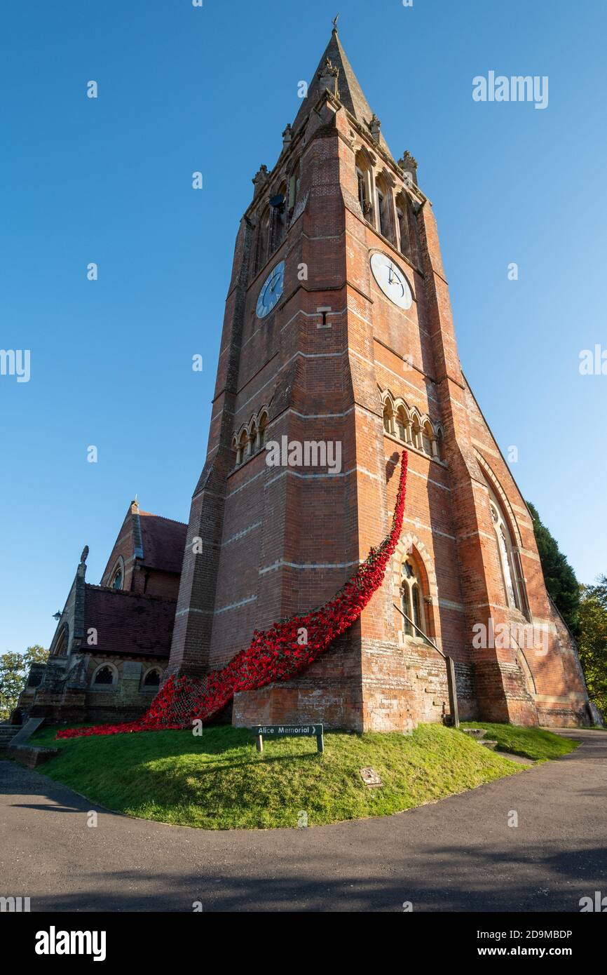 Lyndhurst, Hampshire, UK. 6th November, 2020. The Poppy Appeal has had to adapt this year because of the second lockdown in England due to the coronavirus covid-19 pandemic, and people have been finding different ways to commemorate Remembrance Day. The Church of St Michael's and All Angels in Lyndhurst has been decorated with knitted and crocheted red poppies made by the local community to create a 'fall of poppies for our fallen'. Stock Photo