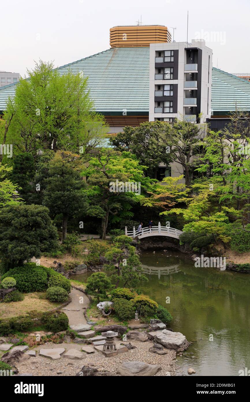 Historical Kyu-Yasuda Garden with Ryōgoku Sumo Hall in the background. Ryogoku district.Sumida City,Tokyo,Japan Stock Photo