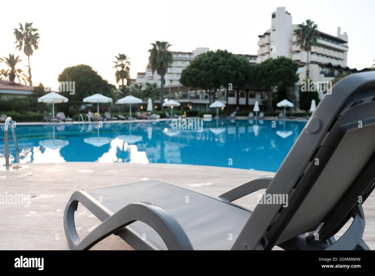 Luxury swimming pool at beautiful hotel. Tropical vacation or weekend getaway for couple. All inclusive luxurious five star resort. Sunbeds, umbrellas Stock Photo