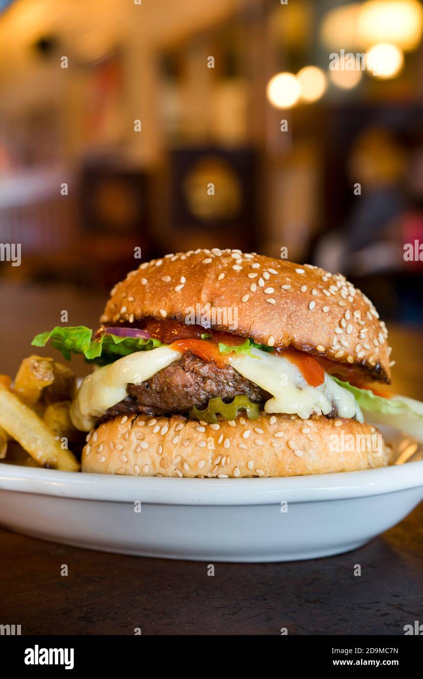 All-American Cheeseburger with fries served at a restaurant Stock Photo ...