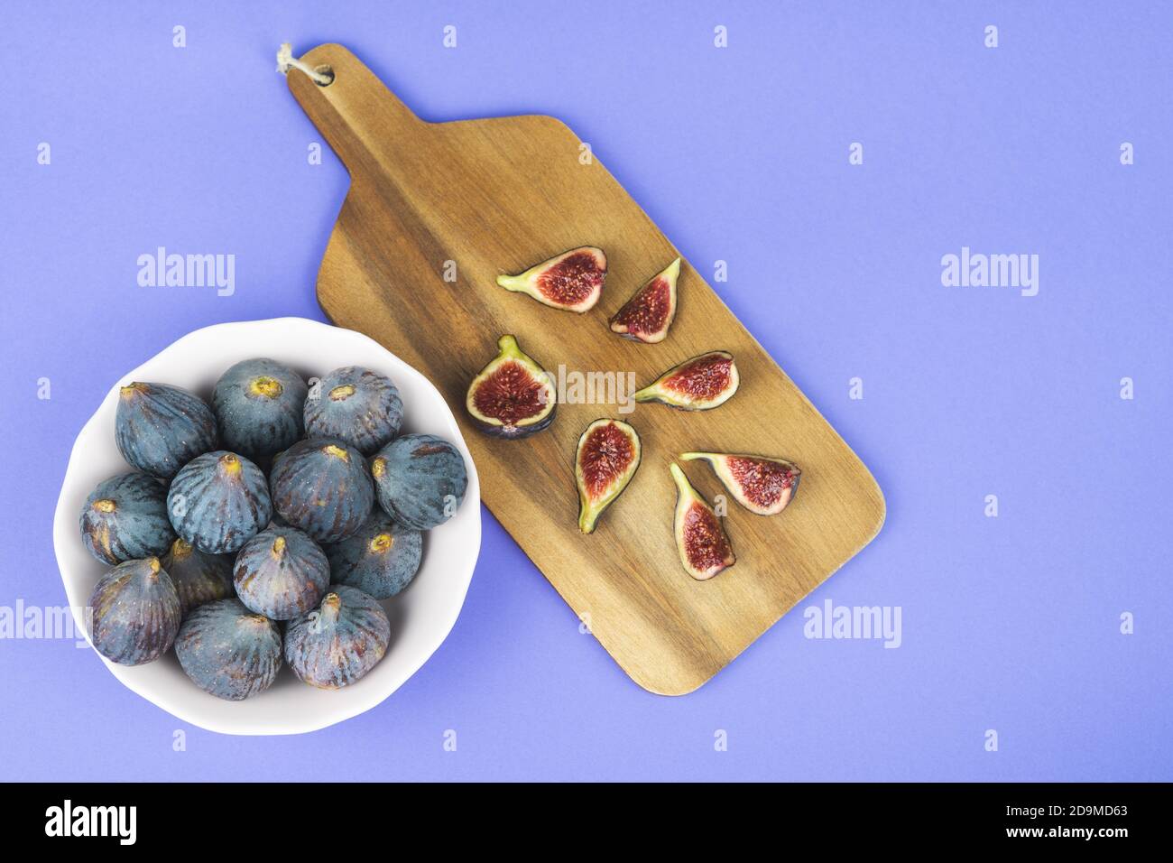 Whole and cut figs on a blue background. Copy space. Stock Photo