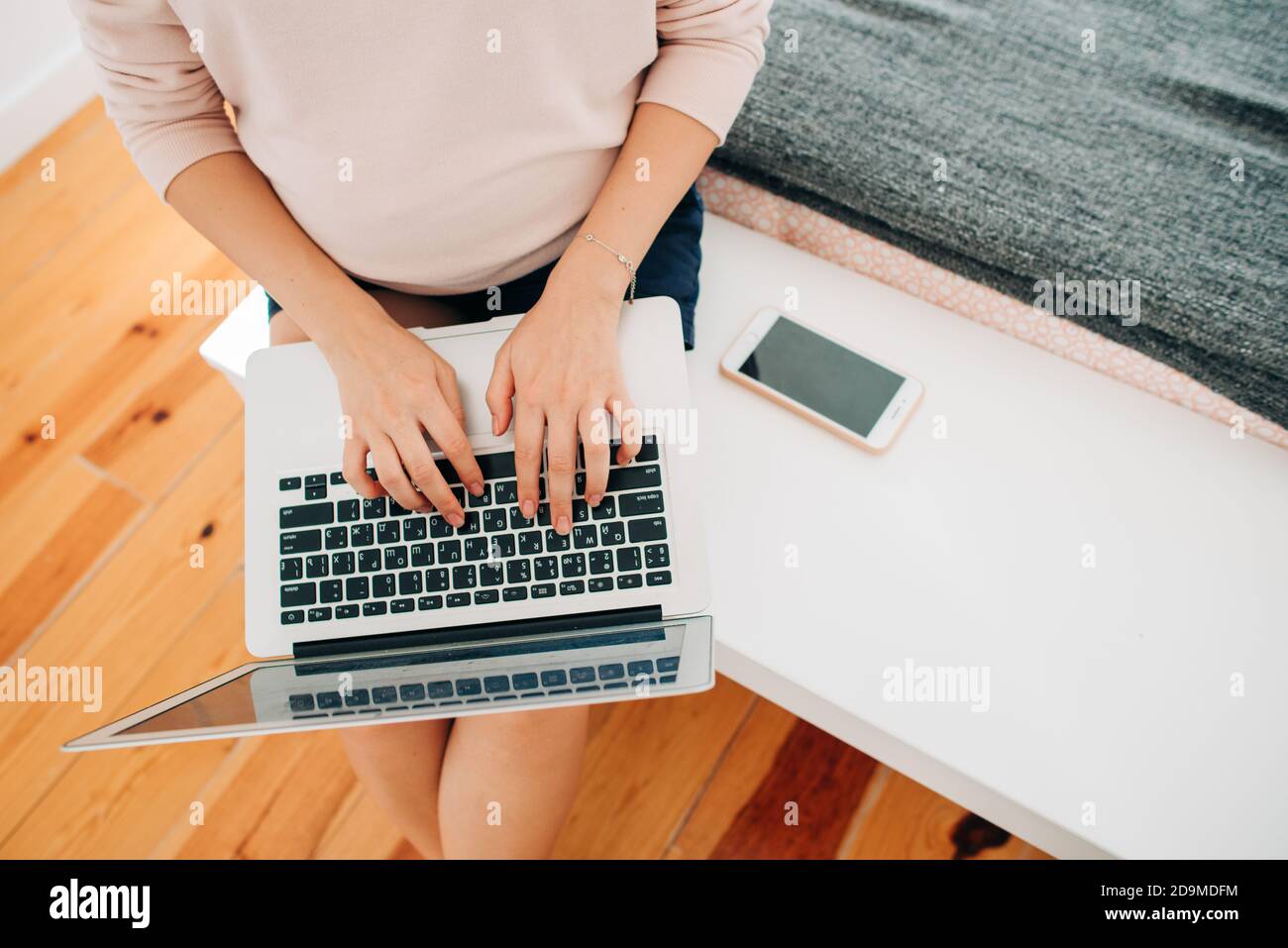 Unrecognisable woman typing on laptop while sitting, top view Stock Photo