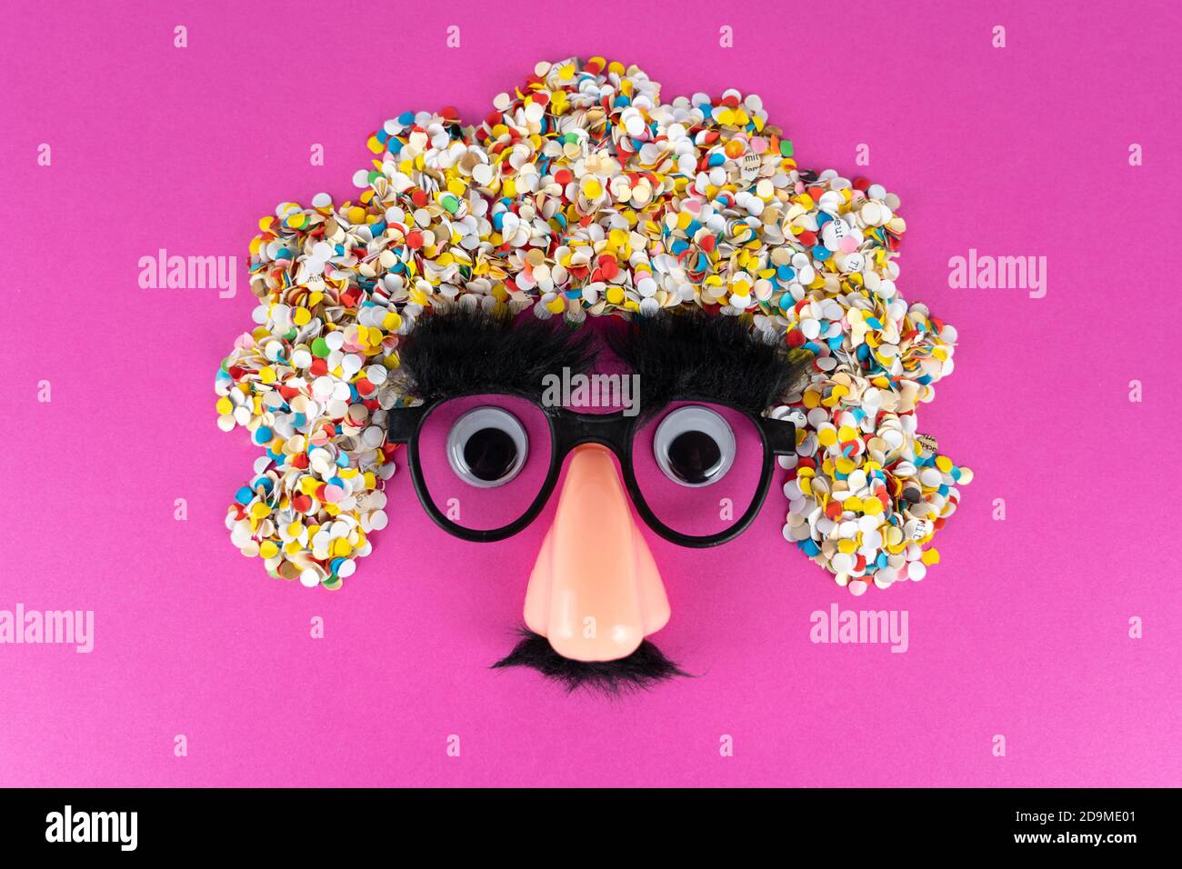 Funny face mask with big eyes and confetti hair Stock Photo - Alamy