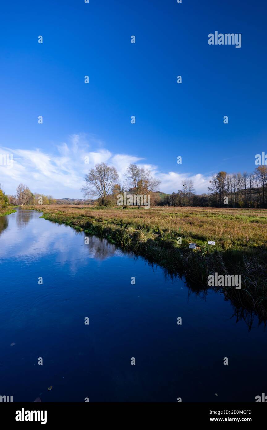 The river Itchen reflects blue skies on a sunny November day just outside the city of Winchester in Hampshire, England. Stock Photo