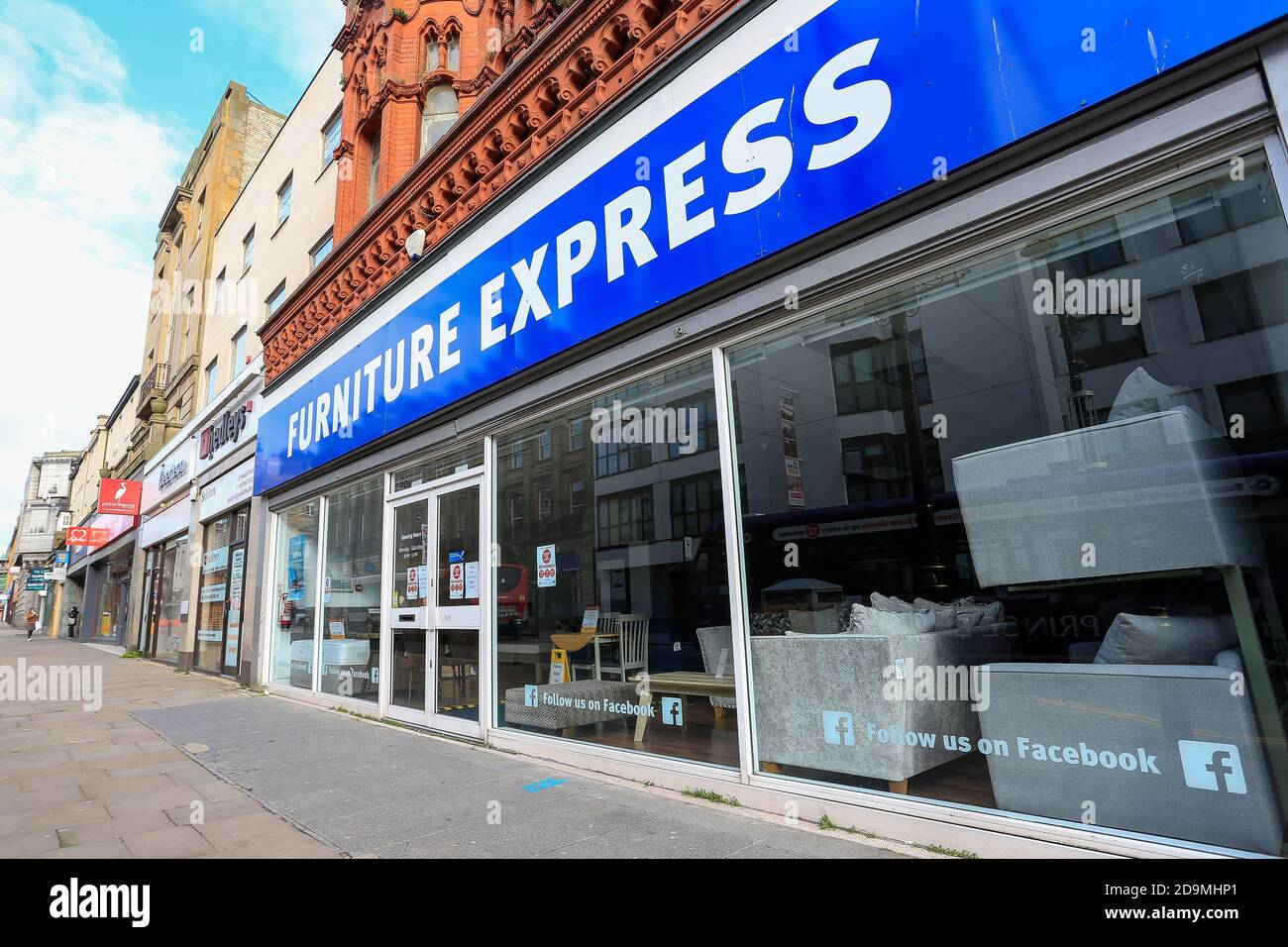Wide shot of a sign in the window of Furniture Express in Fawcett