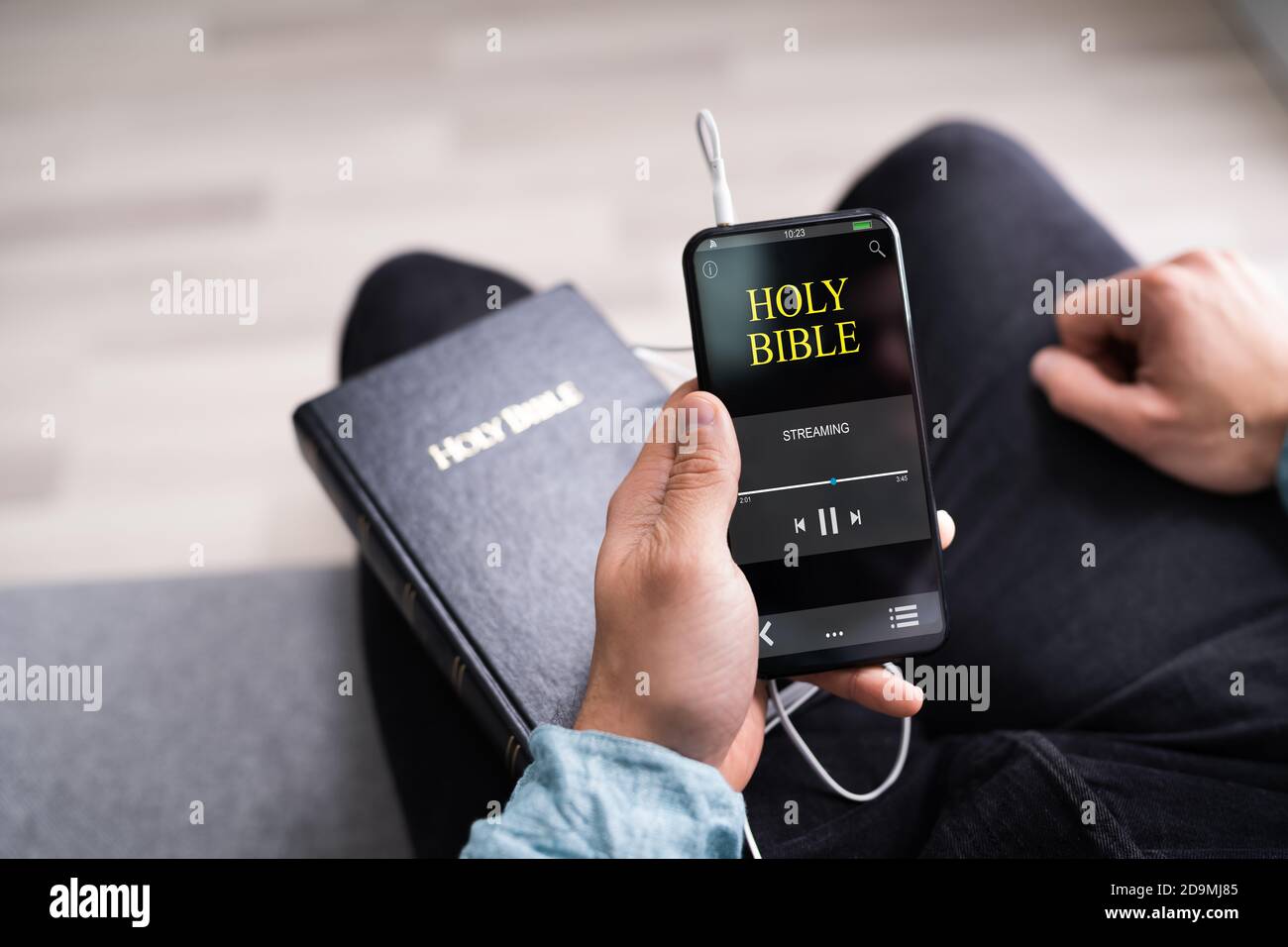 Christian Man Reading Bible Book On Phone And Praying Stock Photo