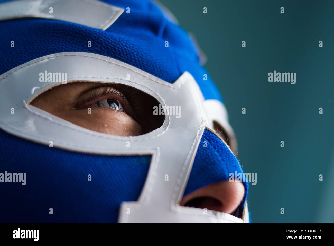 Close up of blue eyed man wearing  a blue wrestling mask Stock Photo
