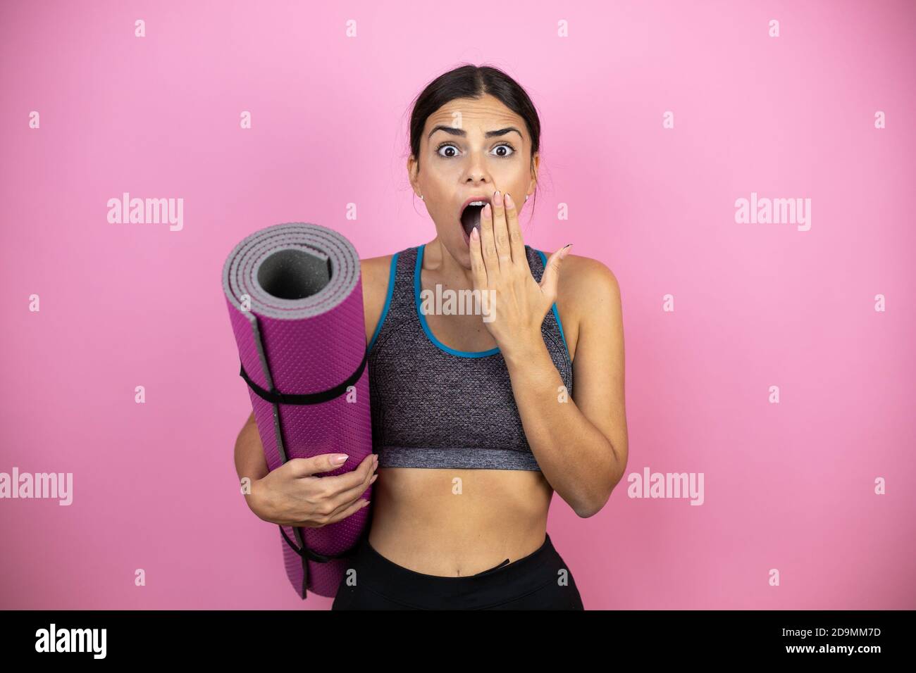 Young beautiful woman wearing sportswear over isolated pink background ...