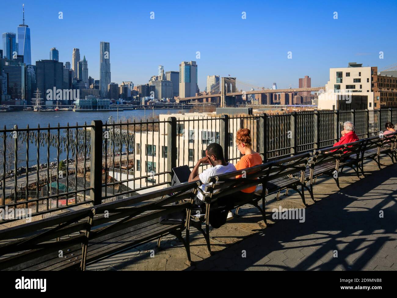 New York City, New York, United States of America - People on Brooklyn Heights waterfront, looking towards Manhattan skyline and Brooklyn Bridge, USA. Stock Photo