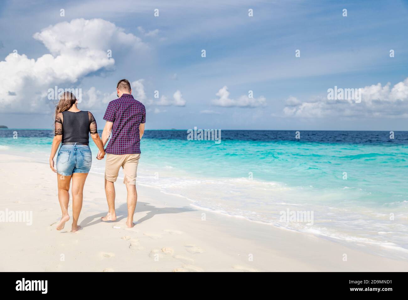 Couple walking on beach. Luxury summer honeymoon vacation destination. Tropical nature beach scenery Stock Photo