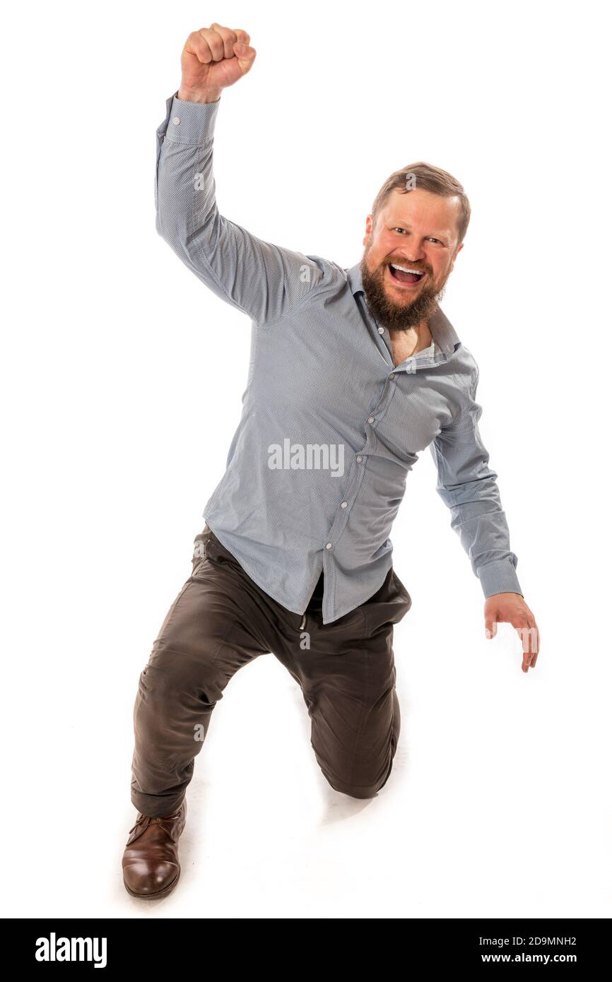 Joyful bearded man in shirt is happy to win emotional studio portrait ...