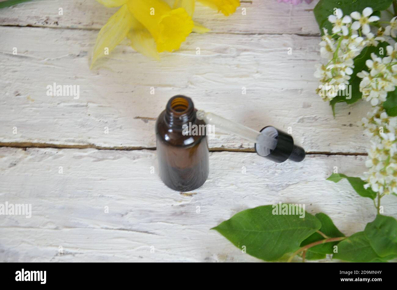 Bottles of essential aromatic or medical oils surrounded by fresh