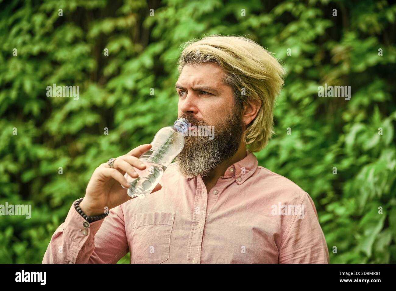 fresh and healthy water from bottle. healthcare and water balance concept. need to quench thirst. refresh in hot weather. moisturize dry mouth. bearded mature man drinking some water. Stock Photo