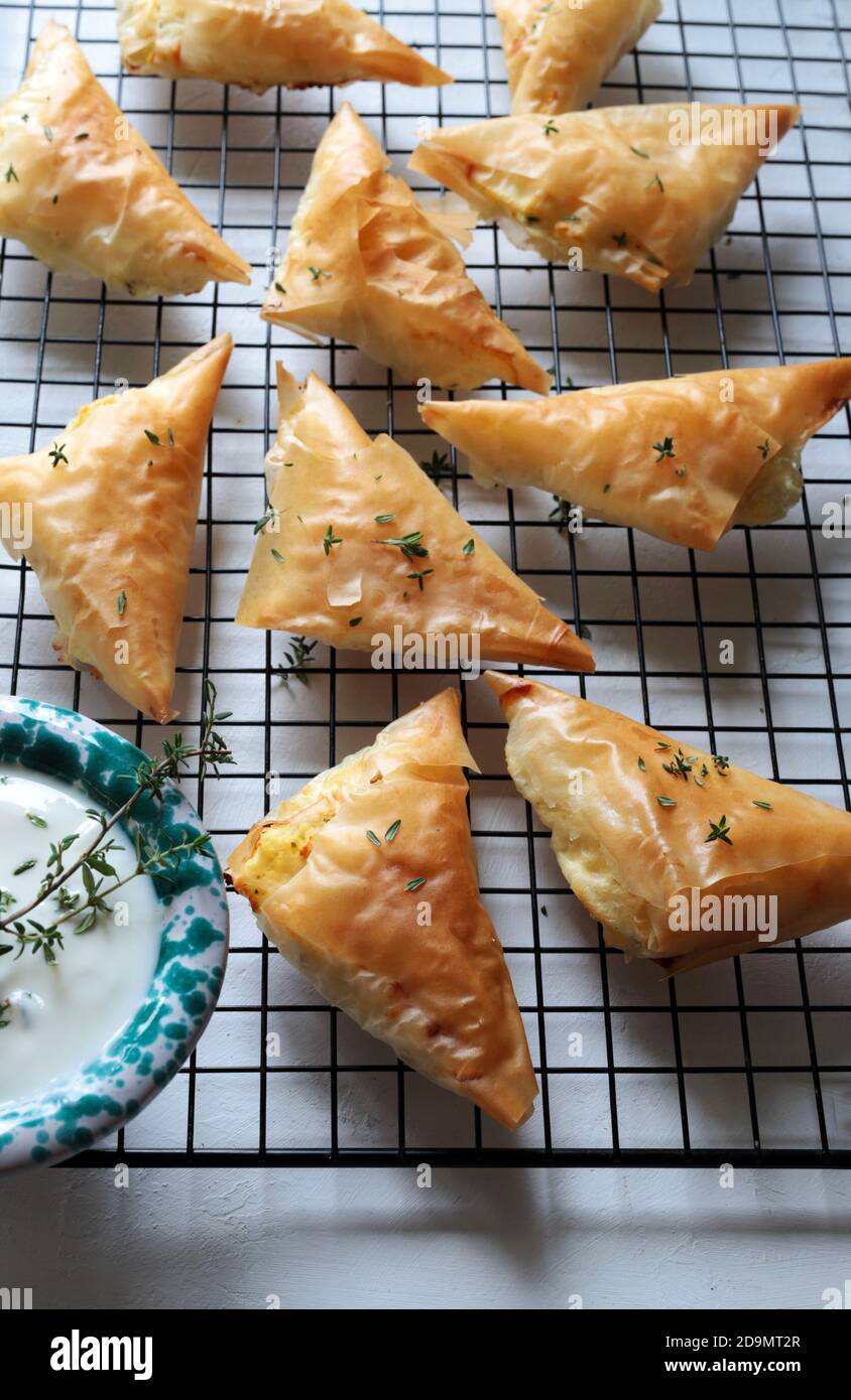 Greek cuisine. Tiropita, greek feta cheese triangle pies on white