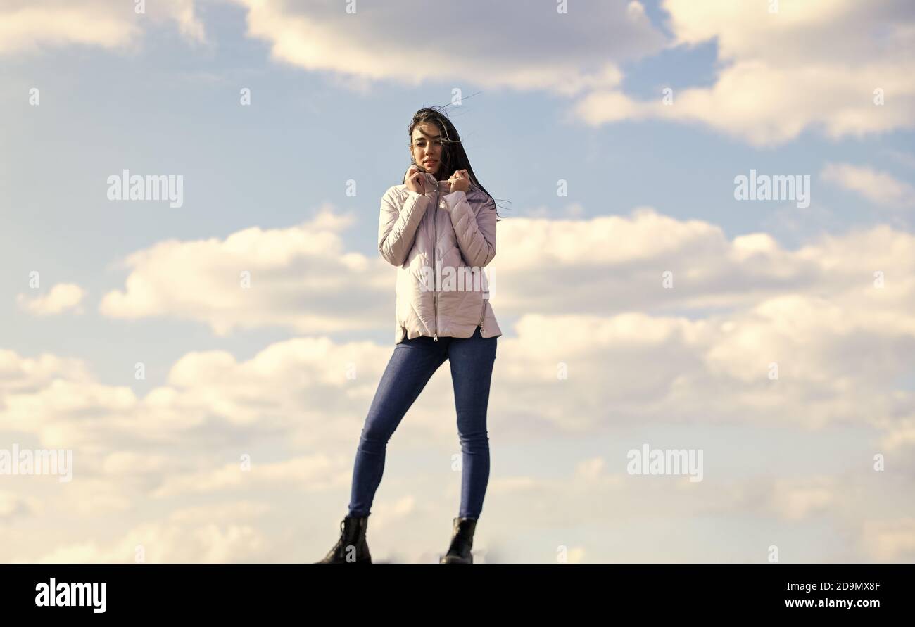 girl wear jacket in city street. Stylish fashion model outdoor. People freedom style. Winter Warm Clothing. girl wearing casual jeans clothes. enjoys sunny day and blue sky. beauty and fashion. Stock Photo