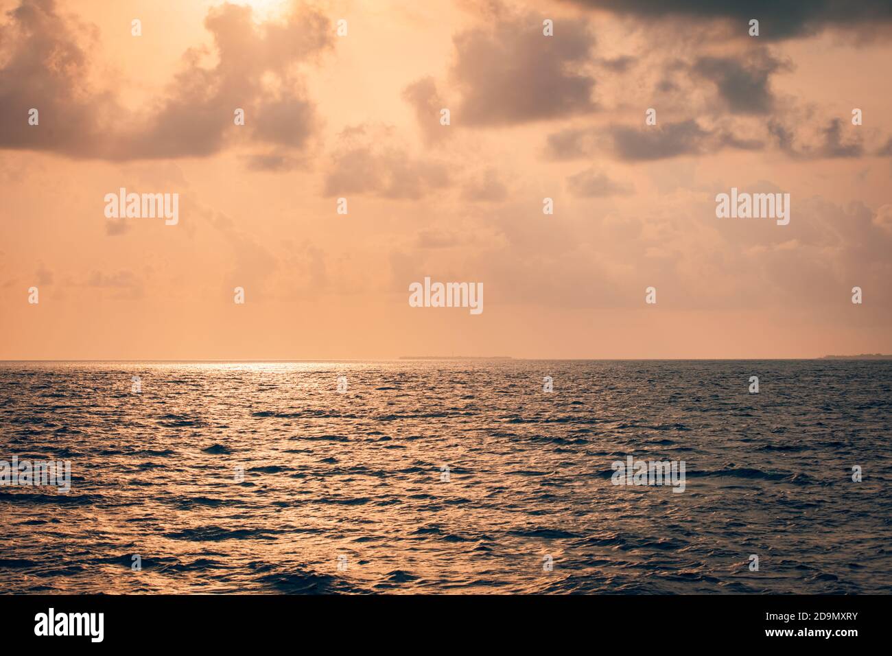 Calm sea with sunset sky and sun through the clouds over. Meditation positive vibes ocean sky background. Tranquil seascape. Horizon over the water. Stock Photo