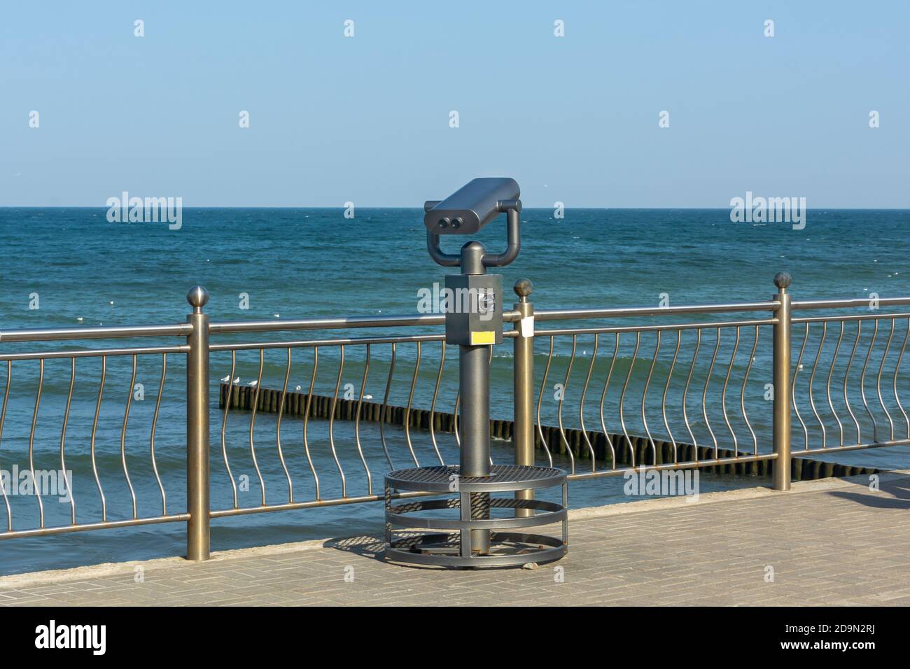Tourist binoculars on the seashore. Optical device for increasing  scale of seascape. Stock Photo