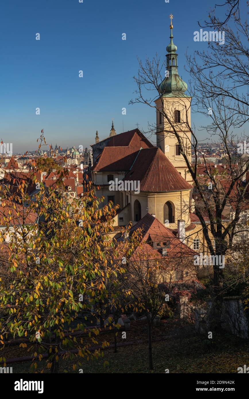 Church of Our Lady Victorious (Shrine of the Infant Jesus of Prague), a rear view from gardens on slopes of Petřín hill. Autumn scene with blue sky. Stock Photo
