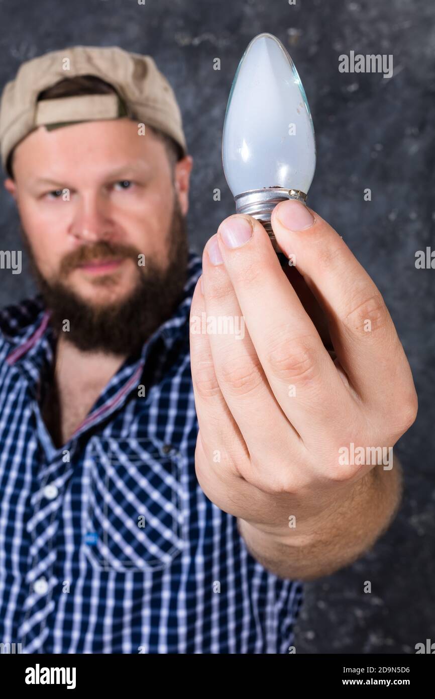 Solid bearded man at casual clothes with a bulb  lamp studio portrait Stock Photo