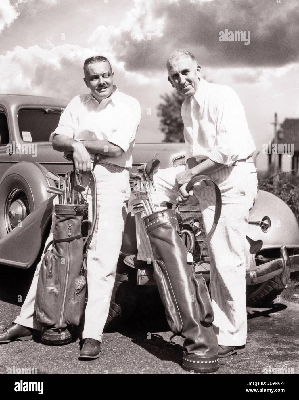 1930s 1940s TWO MATURE CASUALLY DRESSED MEN LEANING ON AUTOMOBILE FENDER EACH HOLDING GOLF BAG AND CLUBS - g5259 HAR001 HARS FRIEND WEALTHY COMPETITION ATHLETE RELAXING RICH PLEASED JOY LIFESTYLE SATISFACTION HEALTHINESS LUXURY COPY SPACE FRIENDSHIP FULL-LENGTH PHYSICAL FITNESS PERSONS AUTOMOBILE MALES GOLFING ATHLETIC RETIREMENT SENIOR MAN TRANSPORTATION SENIOR ADULT MIDDLE-AGED B&W CLUBS MIDDLE-AGED MAN RETIREE SKILL ACTIVITY AMUSEMENT HAPPINESS PHYSICAL WELLNESS CHEERFUL GOLFERS HOBBY LEISURE STRENGTH INTEREST AUTOS HOBBIES KNOWLEDGE RECREATION PASTIME PRIDE PLEASURE SMILES CONNECTION Stock Photo