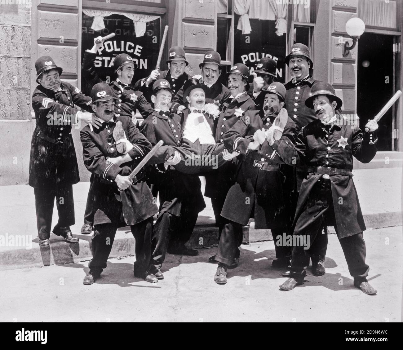 1910s 1912-1917 KEYSTONE COPS AND BEN TURPIN MACK SENNETT HOLLYWOOD SLAPSTICK COMEDY SILENT MOVIE STILL  - h9864 NAW001 HARS PROTECT SKILLS PERFORMER AND CAREERS EXCITEMENT COMICAL ENTERTAINER KEYSTONE OCCUPATIONS UNIFORMS BEN ACTORS COMEDY SILENT MOVIE SLAPSTICK MOTION PICTURE OFFICERS POLICEMEN PUBLICITY STILL COPS ENTERTAINERS FICTIONAL INCOMPETENT MACK MOVIE STILL PERFORMERS SILENT FILM BADGE BADGES BEN TURPIN BLACK AND WHITE CAUCASIAN ETHNICITY MACK SENNETT OLD FASHIONED Stock Photo