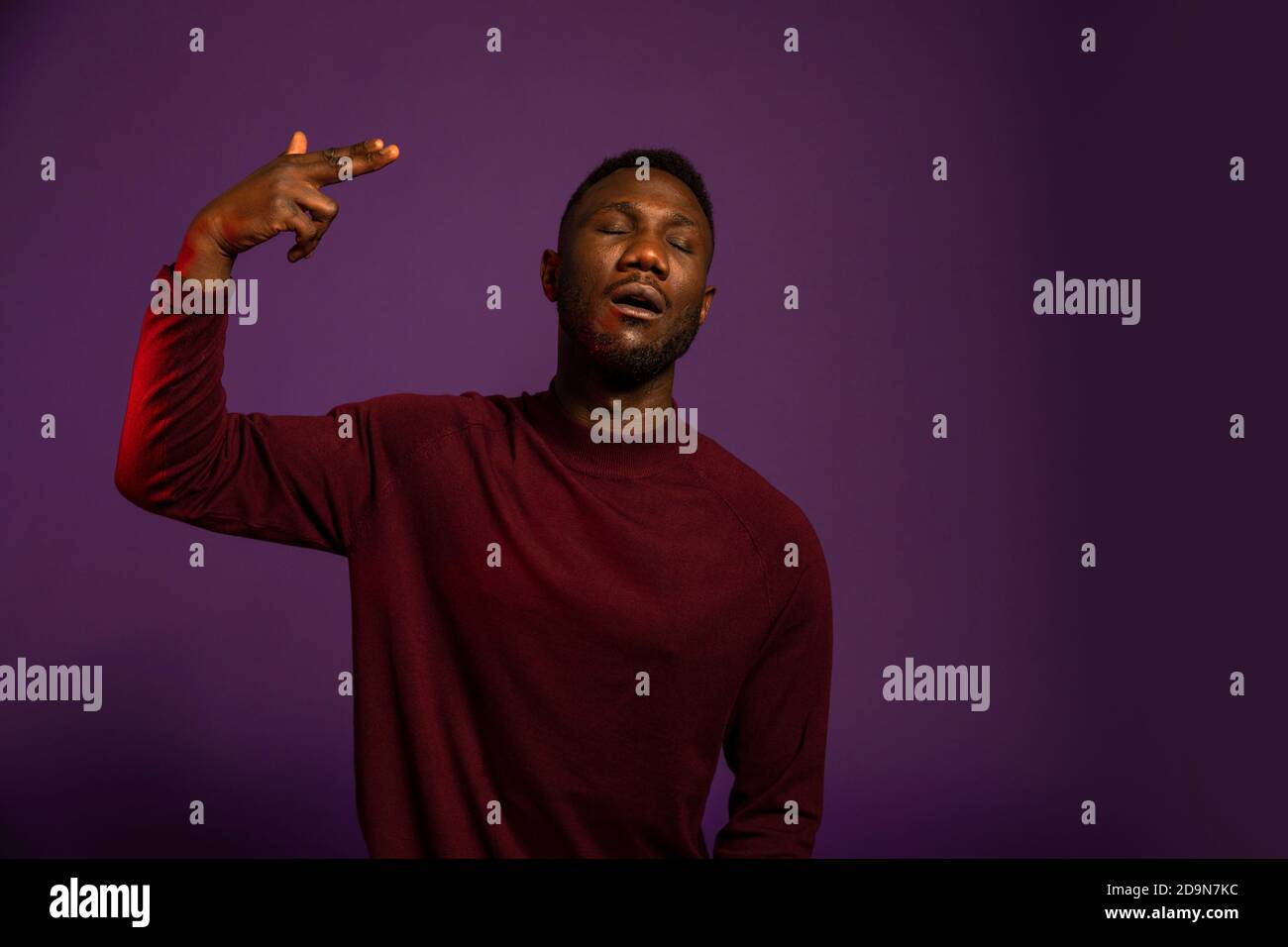 Black man showing I show myself hand gesture, body language, and facial expression. Isolated background. Front view. Medium shot. Stock Photo