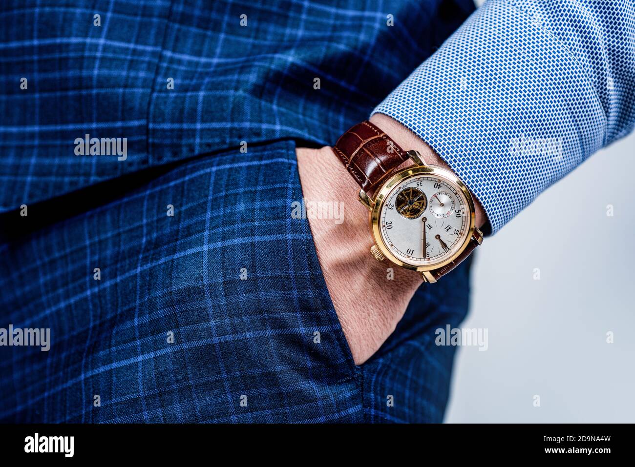 Analog wrist watch worn on male arm in trousers pocket, wristwatch