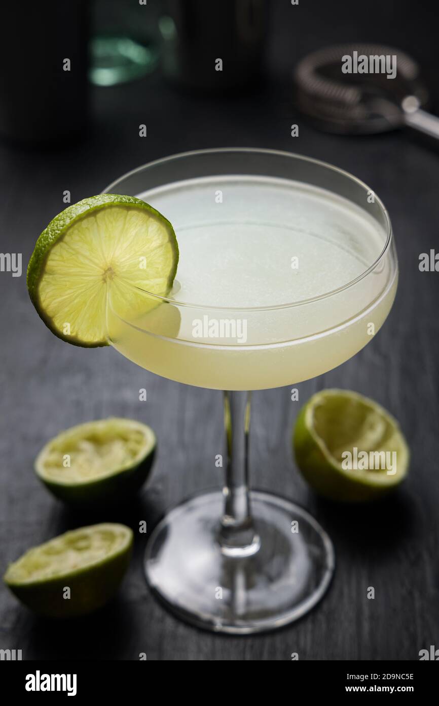 Classic Daiquiri Cocktail with a lime wheel. Squeezed limes over a black table Stock Photo Alamy