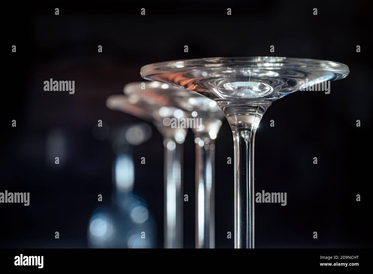 Detail of three glasses standing upside down on a dark background Stock