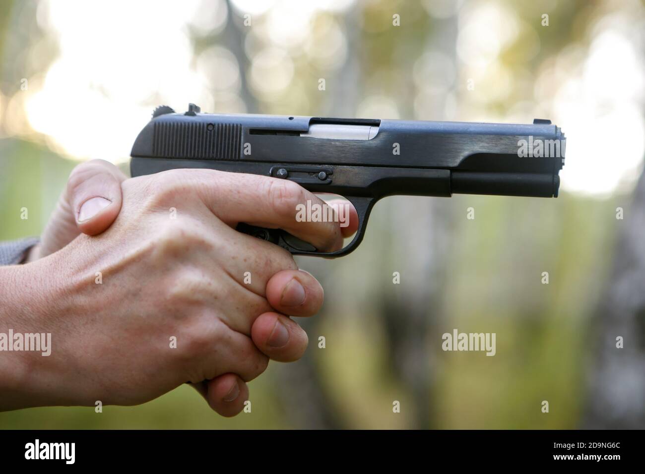 The shooter must aim the gun. Hands holding weapons Stock Photo