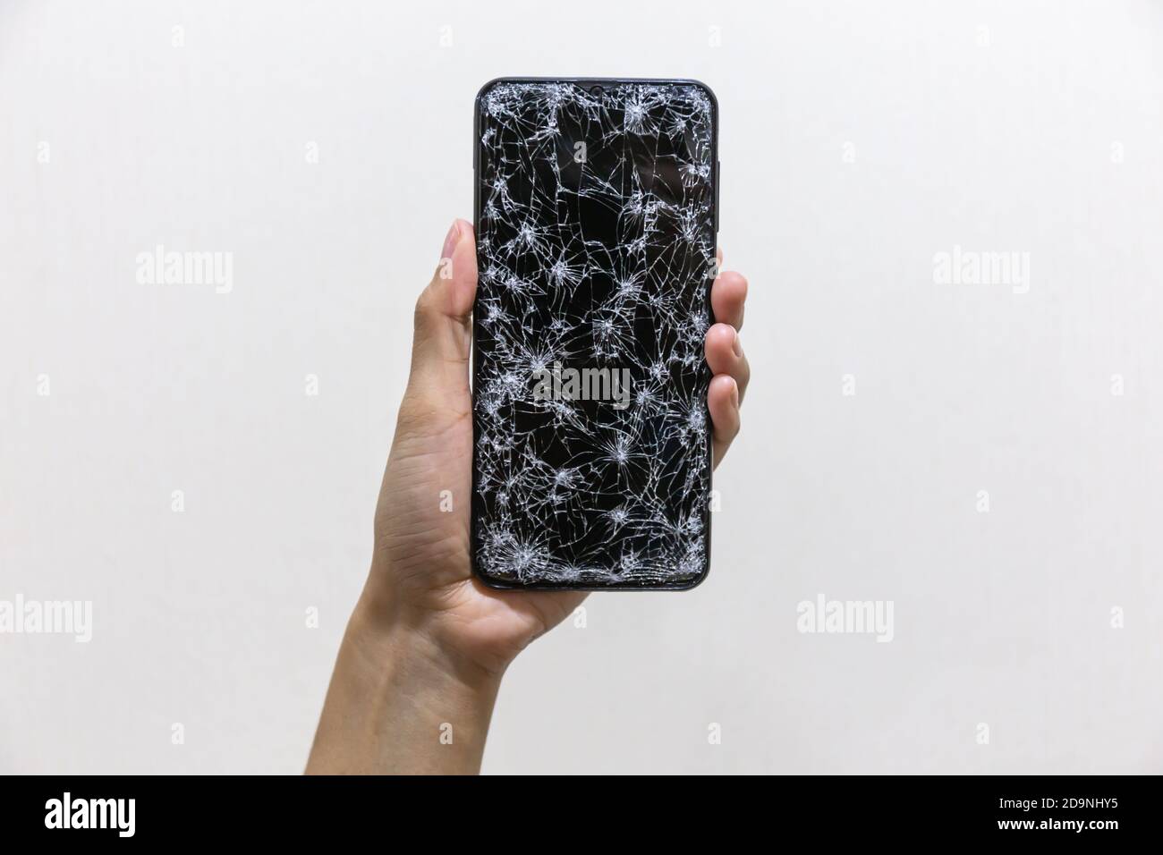 Woman hands holding smartphone with broken or cracked screen on white ...