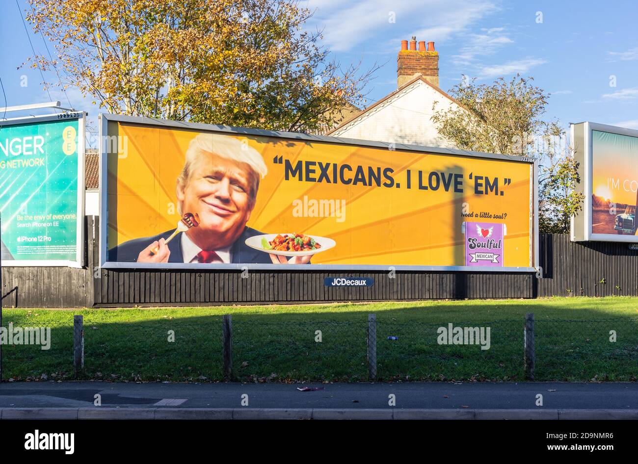 An orange coloured billboard display for the vegan food brand 'Soulful' portraying Donald Trump enjoying a plate of Mexican food stating 'Mexicans I love em' - satire / satirical billboard advertising during November 2020 in Southampton, England, UK Stock Photo