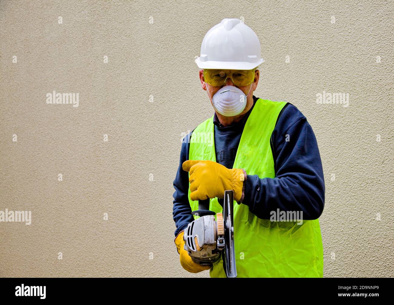 Australian building worker in safety gear using angle grinder in Canberra, the Australian national capital Stock Photo
