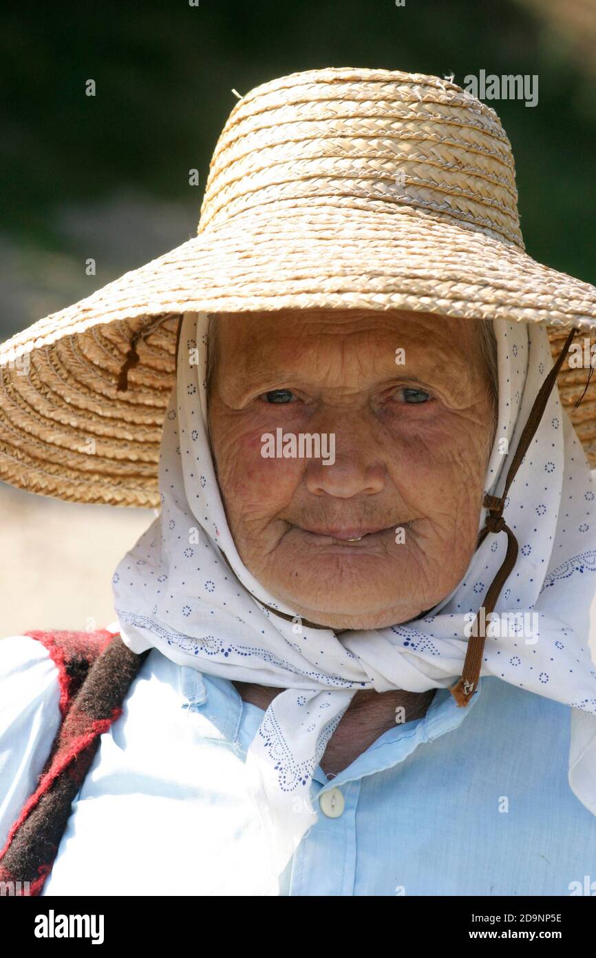 Portrait of an elderly woman wearing a straw hat in Transylvania ...