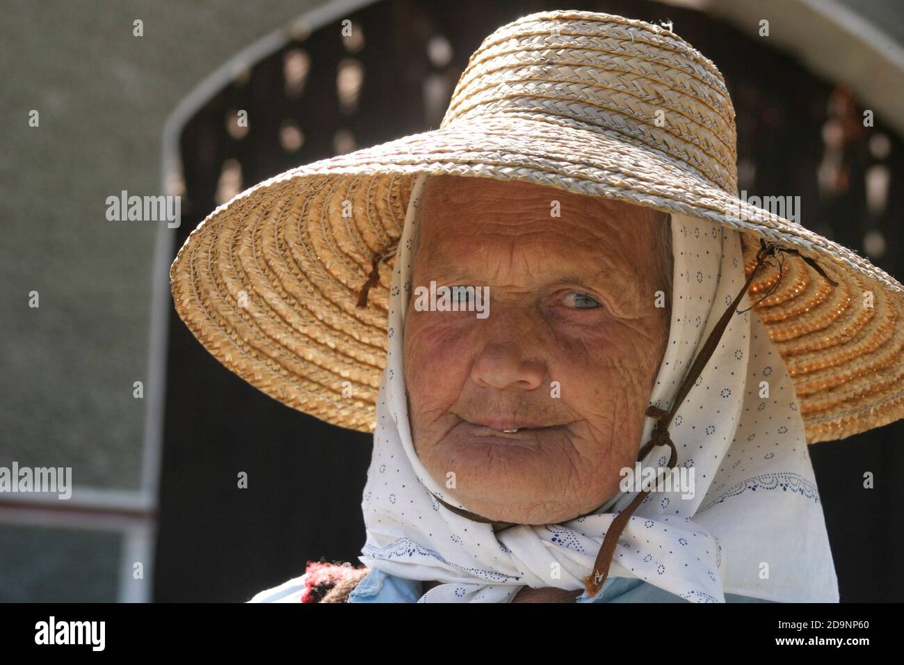Portrait of an elderly woman wearing a straw hat in Transylvania ...