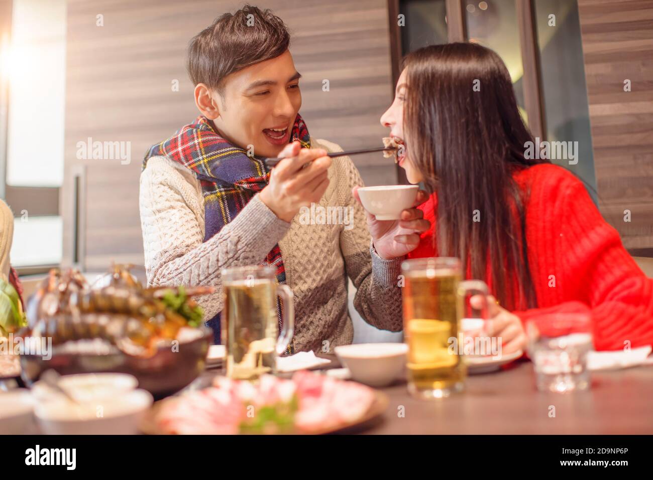 Young man is feeding his girfriend in restaurant Stock Photo