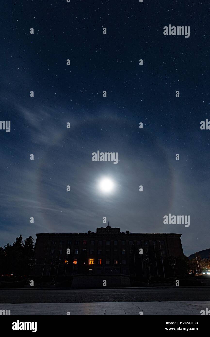 STEPANAKERT, ARTSAKH - Nov 05, 2020: View of the Presidential building during night with a moon halo over it Stock Photo