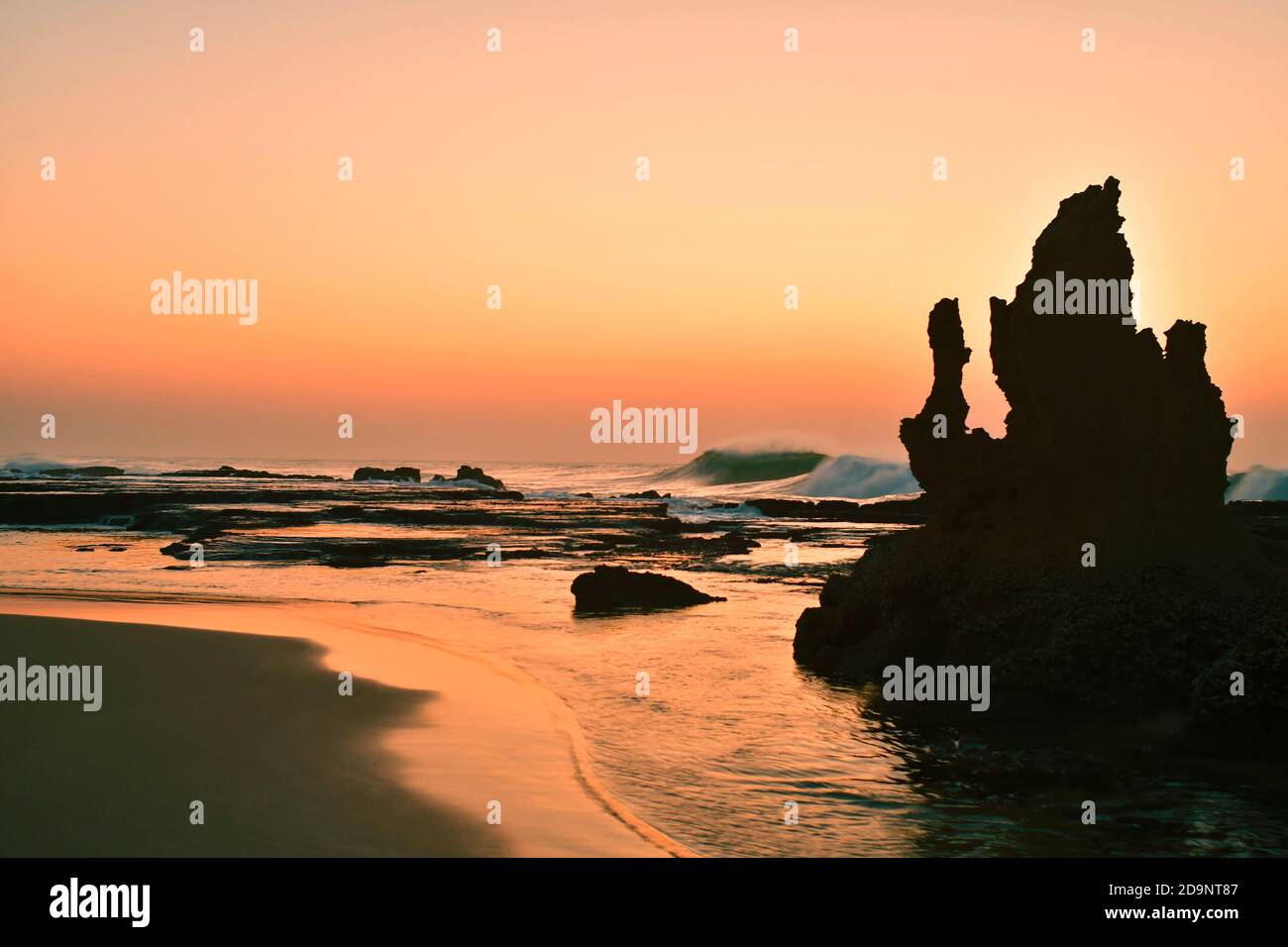Beach at sunrise, rock formation, silhouette, Umhloti Beach, Durban, South Africa Stock Photo