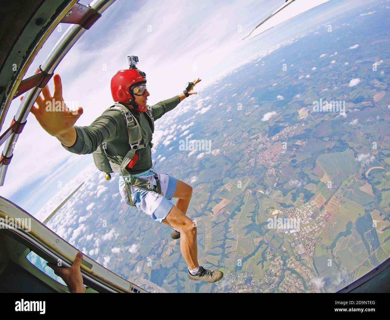 Brave Parachutist with red helmet jump out of the plane Stock Photo