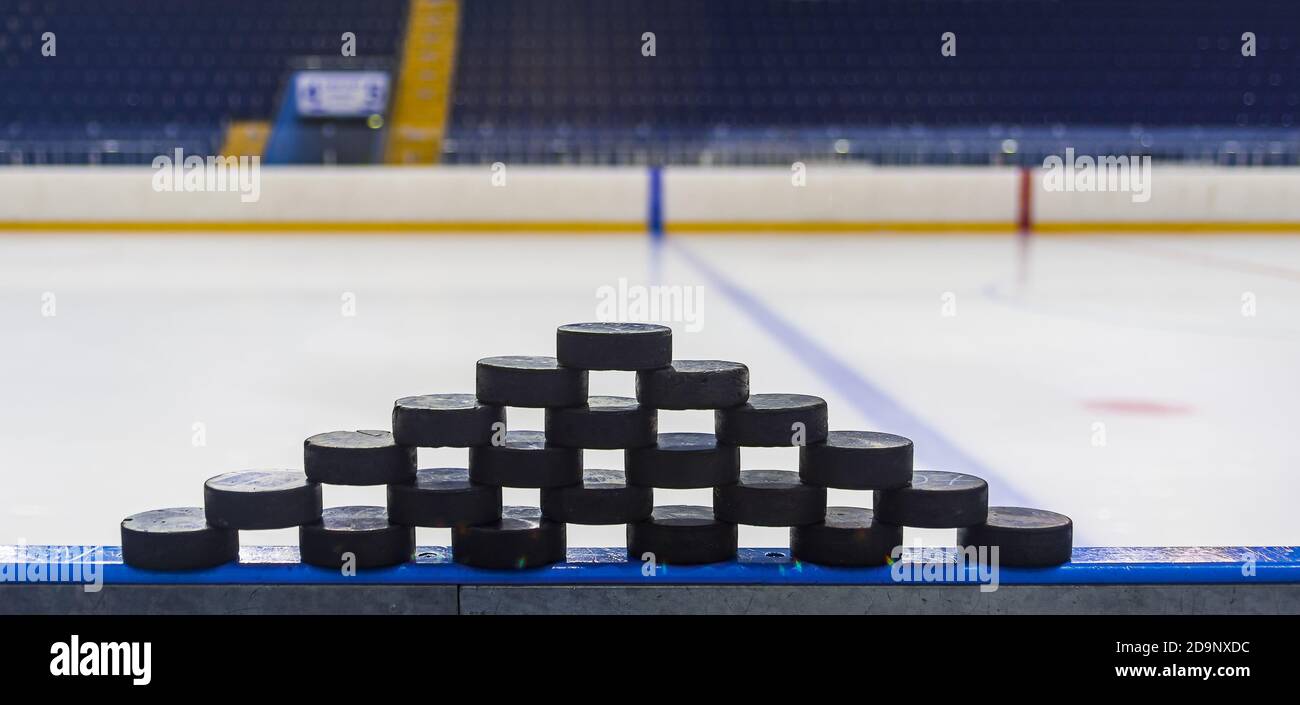 A pyramid made of ice hockey pucks stands on the sides of the ice arena