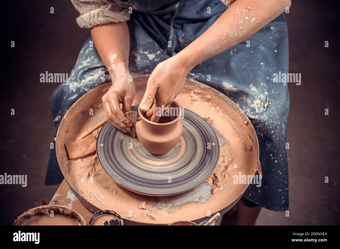 The potter works in the Hands and a potter's wheel closeup