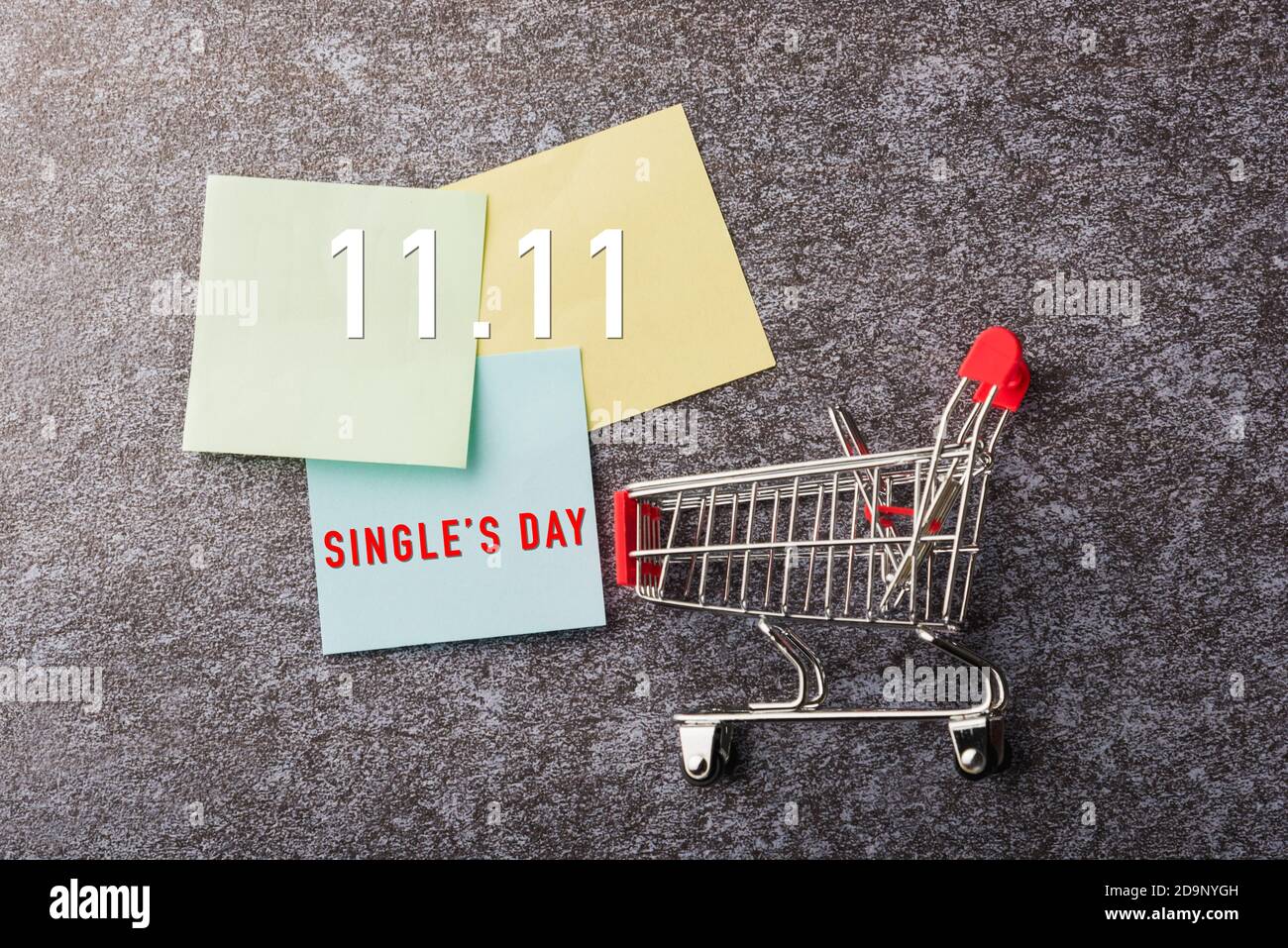 Above blank paper stick note list yellow and green with the shopping cart with 11.11 single's day text on paper on concrete table background, 11:11 Sh Stock Photo