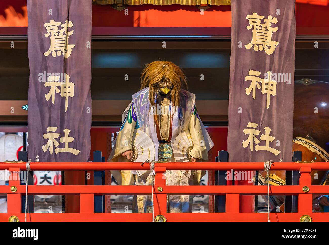 asakusa, japan - november 08 2019: Japanese dancer in kimono wearing an eagle mask and making with a fan a kagura dance in the Ootori shrine during th Stock Photo